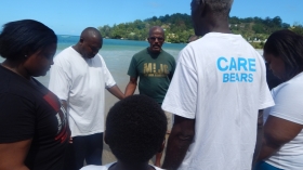 Local Minister Herman Browne prays with candidates