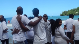 Pastor Dexter Daly prays with candidates