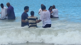 Pastors David Ali, Albert Best, Gregory Isaacs baptise a candidate